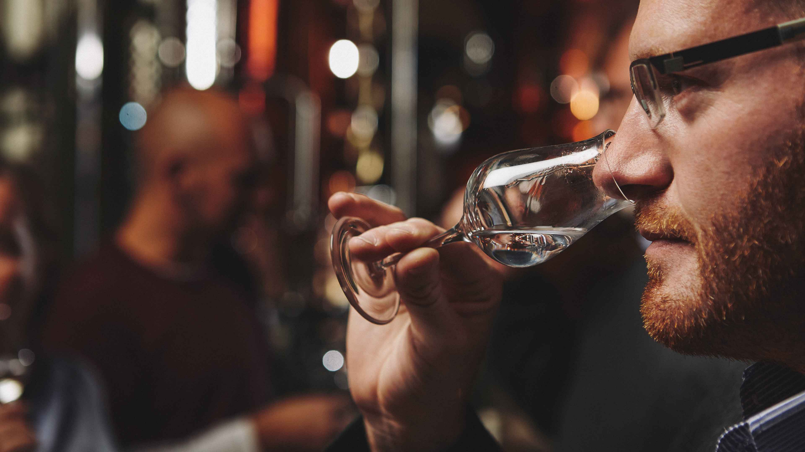 Ein Mann riecht zur Degustation an einem mit Destillat gefüllten Schnapskelch.